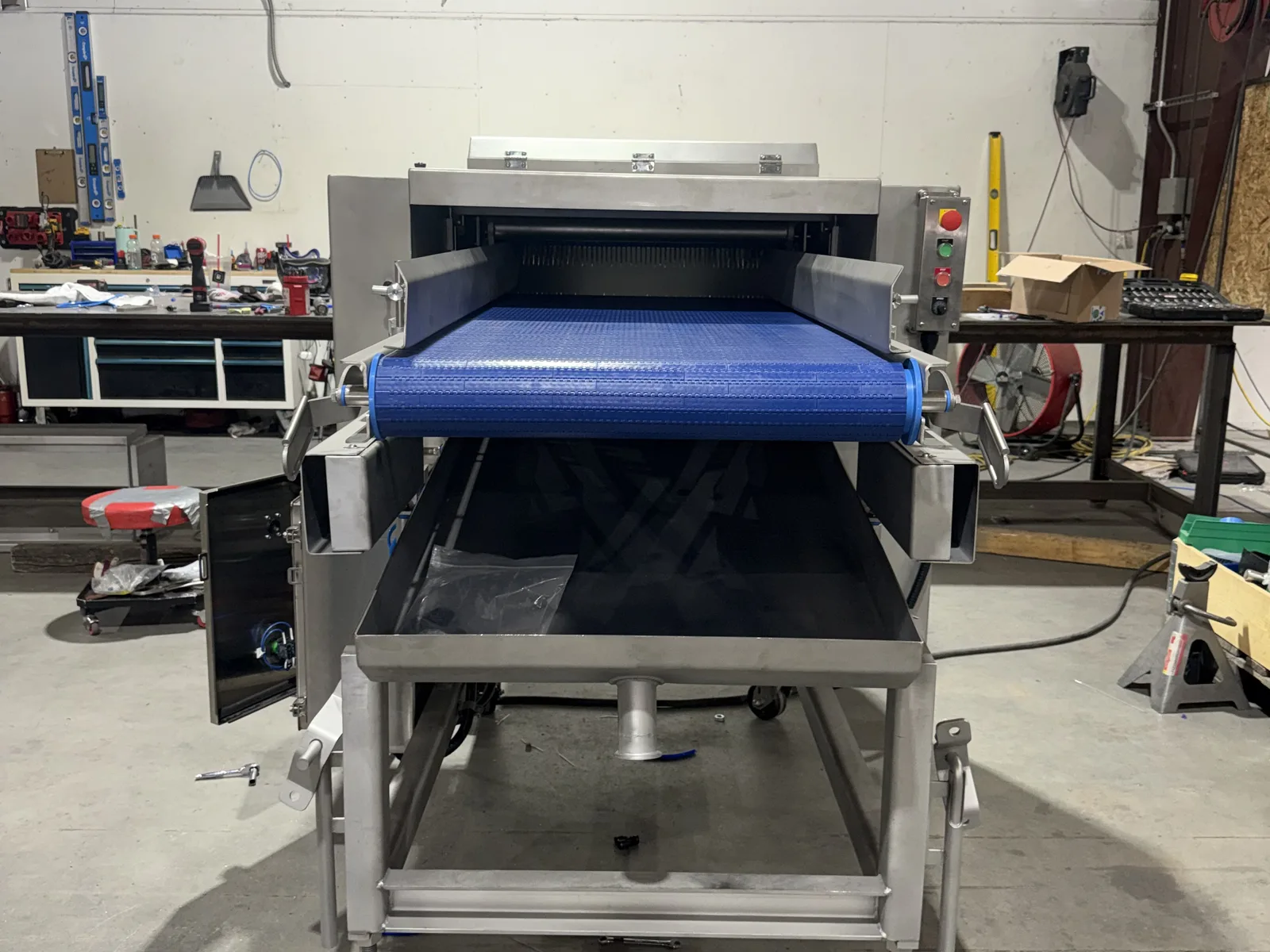 Custom enclosed stainless equipment with control panel and blue modular belt
